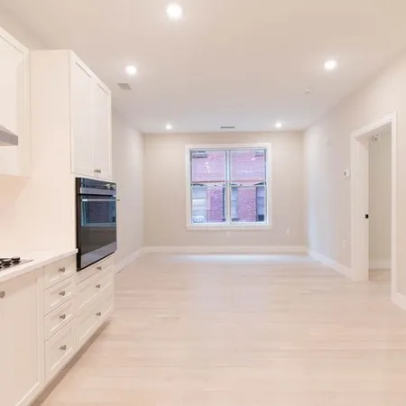 an empty room with windows and cabinet