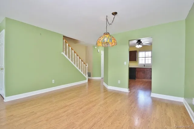 a view of a room with wooden floor potted plants and a chandelier
