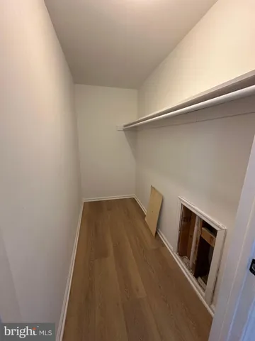 a view of a room with wooden floor and electronic appliances