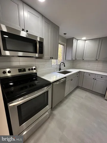 a kitchen with stainless steel appliances a stove a sink and a microwave