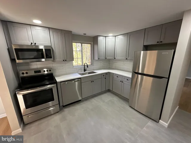 a kitchen with stainless steel appliances a refrigerator sink and microwave