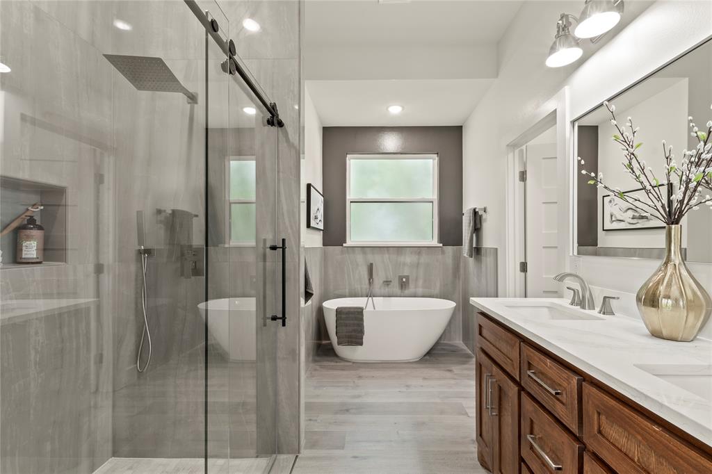 a spacious bathroom with a tub sink and mirror
