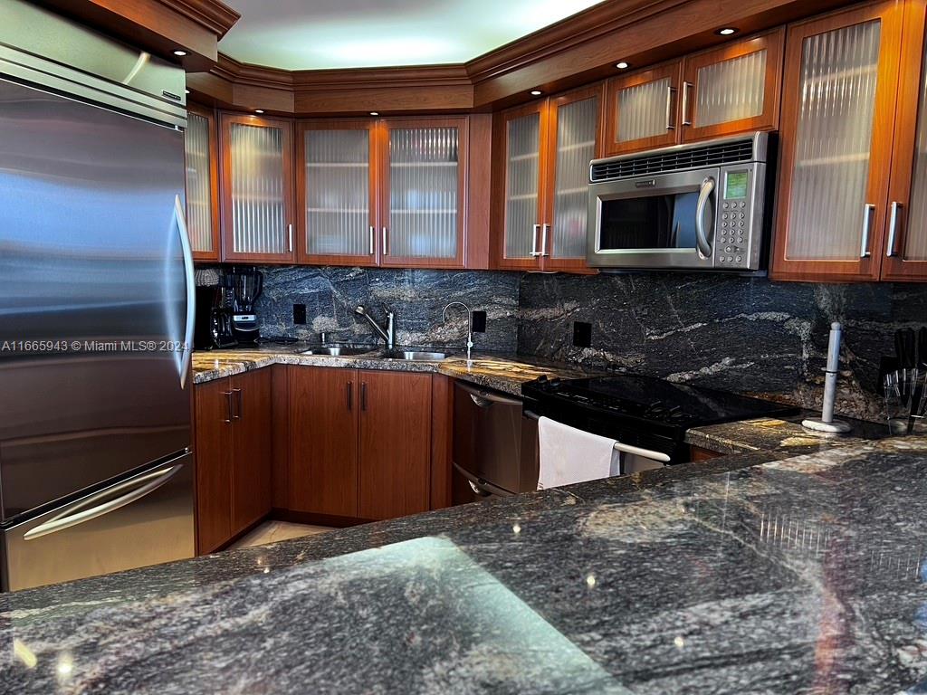 5161 Collins Avenue, Unit 505 Miami Beach, FL 33140 - Photo 20 of 31 a kitchen with kitchen island granite countertop a sink stove and microwave