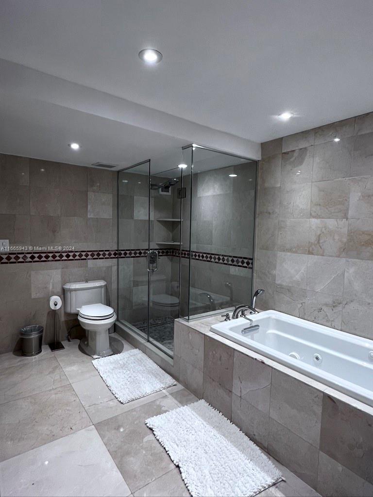 5161 Collins Avenue, Unit 505 Miami Beach, FL 33140 - Photo 24 of 31 a bathroom with a double vanity sink toilet and a tub