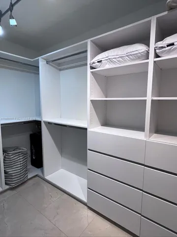 a bedroom with two beds and large window