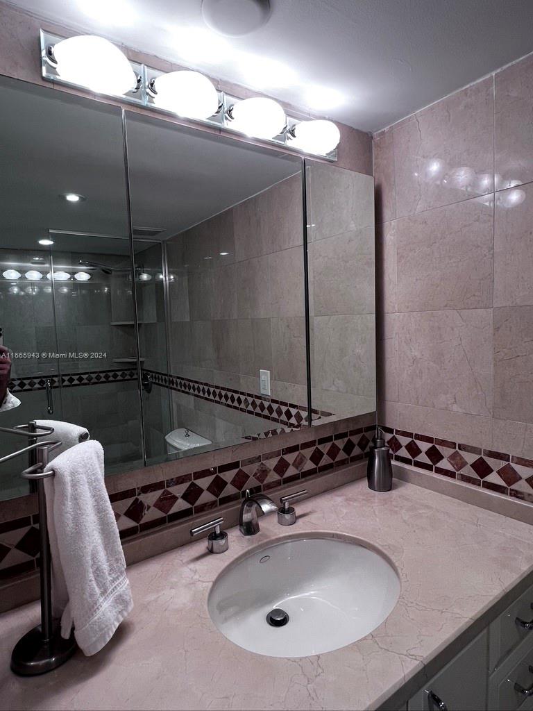 5161 Collins Avenue, Unit 505 Miami Beach, FL 33140 - Photo 30 of 31 a bathroom with a sink and mirror