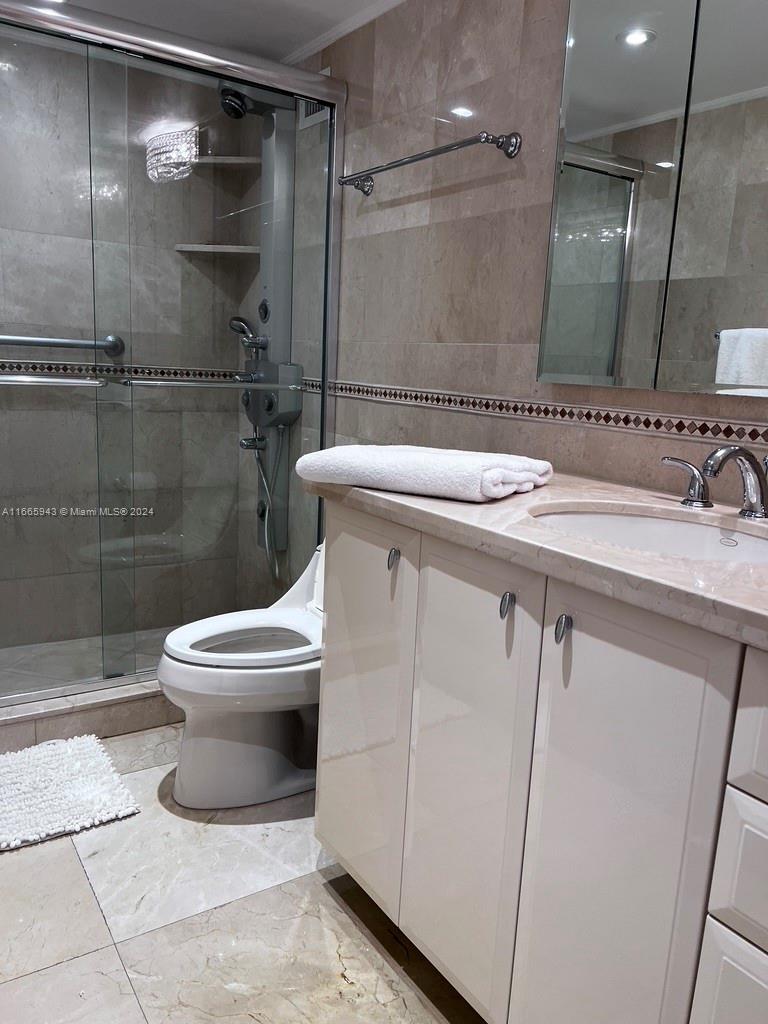 5161 Collins Avenue, Unit 505 Miami Beach, FL 33140 - Photo 31 of 31 a bathroom with a toilet a sink and shower