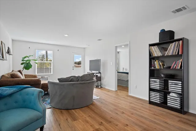 a open kitchen with stainless steel appliances granite countertop a stove top oven a sink dishwasher and a microwave oven with wooden floor