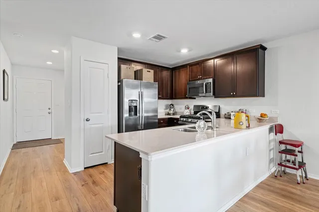 a kitchen with stainless steel appliances granite countertop a refrigerator and a sink