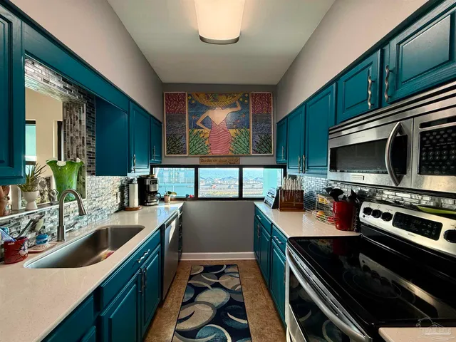 a kitchen with stainless steel appliances a stove sink and microwave