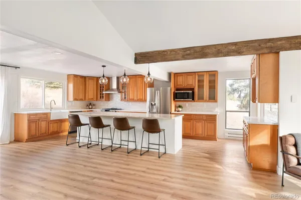 a open kitchen with stainless steel appliances granite countertop a sink a stove and a refrigerator