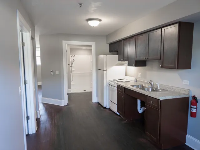 a kitchen with a sink cabinets and wooden floor