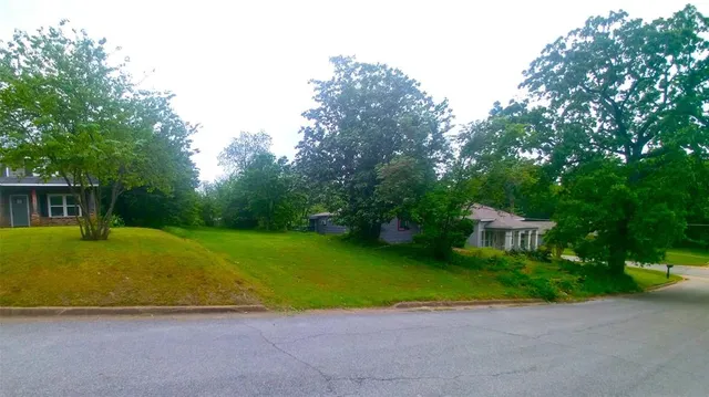 a view of a house with backyard and a tree