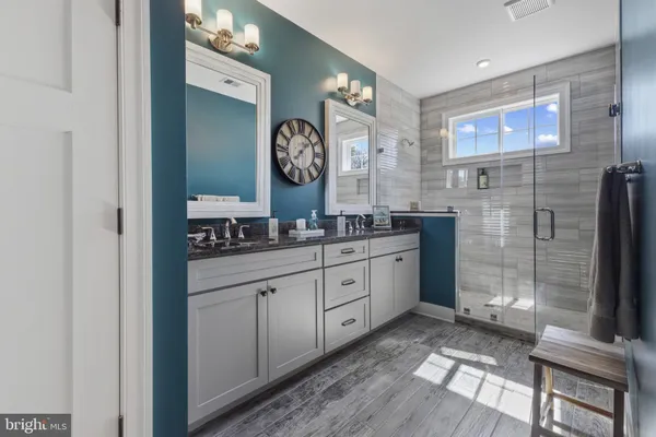a spacious bathroom with double vanity and a mirror