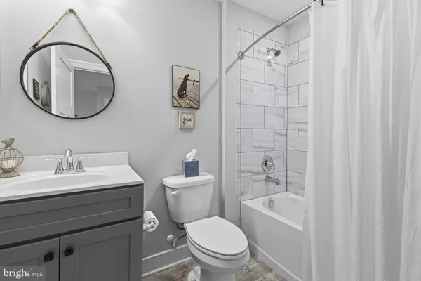 a bathroom with a toilet a sink a mirror and a bathtub