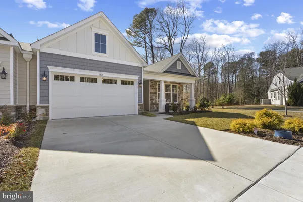 a view of a white house with a large yard and large tree