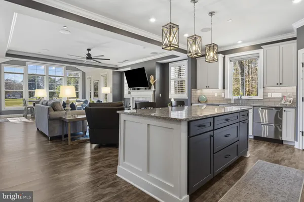 a large kitchen with kitchen island granite countertop a large center island a stove a dining table and chairs