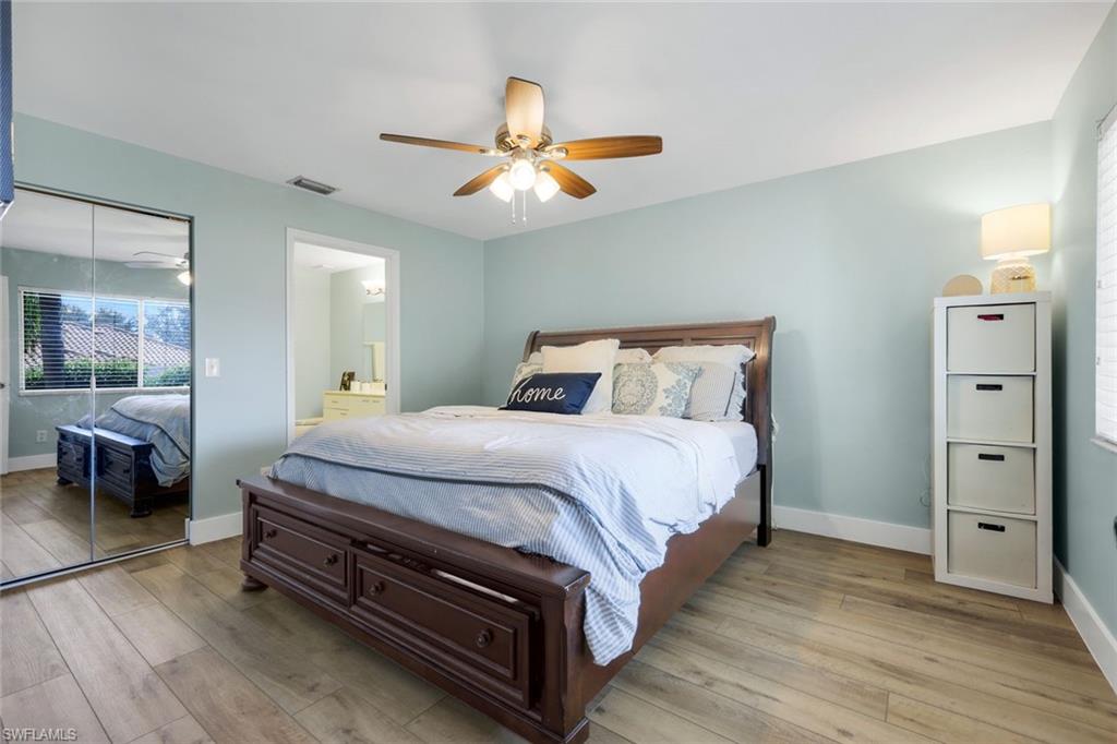 7767 Jewel Lane, Unit 203 Naples, FL 34109 - Photo 11 of 29 a bedroom with a bed and wooden floor