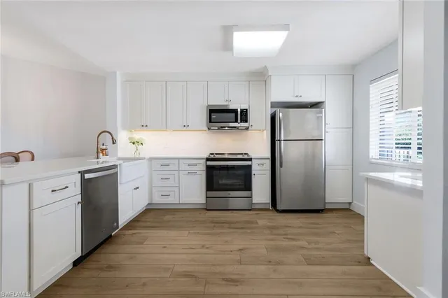 a kitchen with a sink cabinets and wooden floor