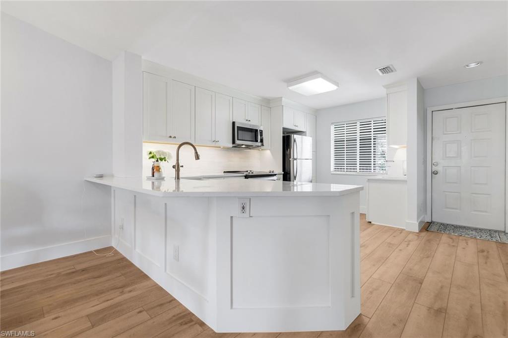 7767 Jewel Lane, Unit 203 Naples, FL 34109 - Photo 3 of 29 a kitchen with granite countertop a sink cabinets and wooden floor
