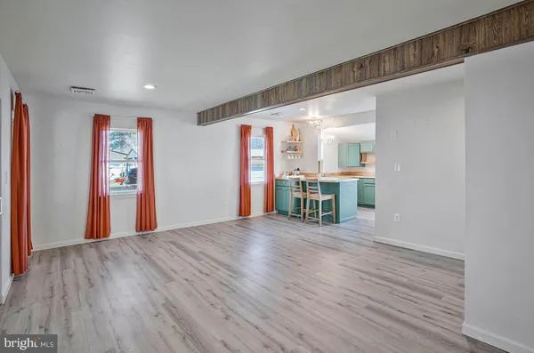 a view of a big room with wooden floor and windows