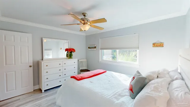 a bedroom with a bed a chandelier and a dresser