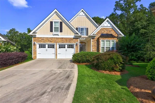 a front view of a house with a yard and potted plants