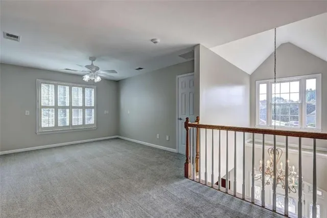 a view of an empty room with a chandelier fan