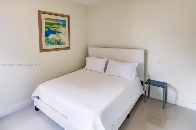 a large bed sitting in a bedroom next to a small small wall