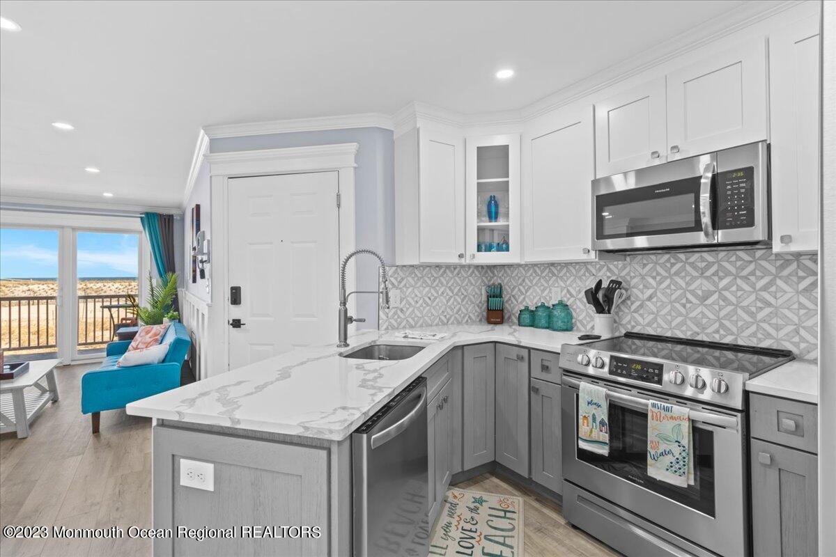 15 Dune Terrace, Unit 15B Seaside Heights, NJ 08751 - Photo 11 of 22 a kitchen with stainless steel appliances granite countertop a kitchen island a stove a sink and a microwave