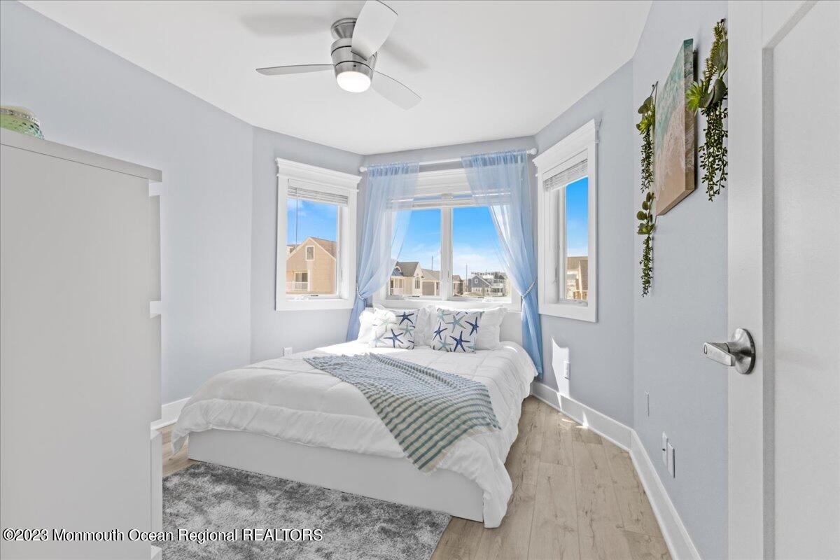 15 Dune Terrace, Unit 15B Seaside Heights, NJ 08751 - Photo 12 of 22 a bedroom with a large bed and a chandelier