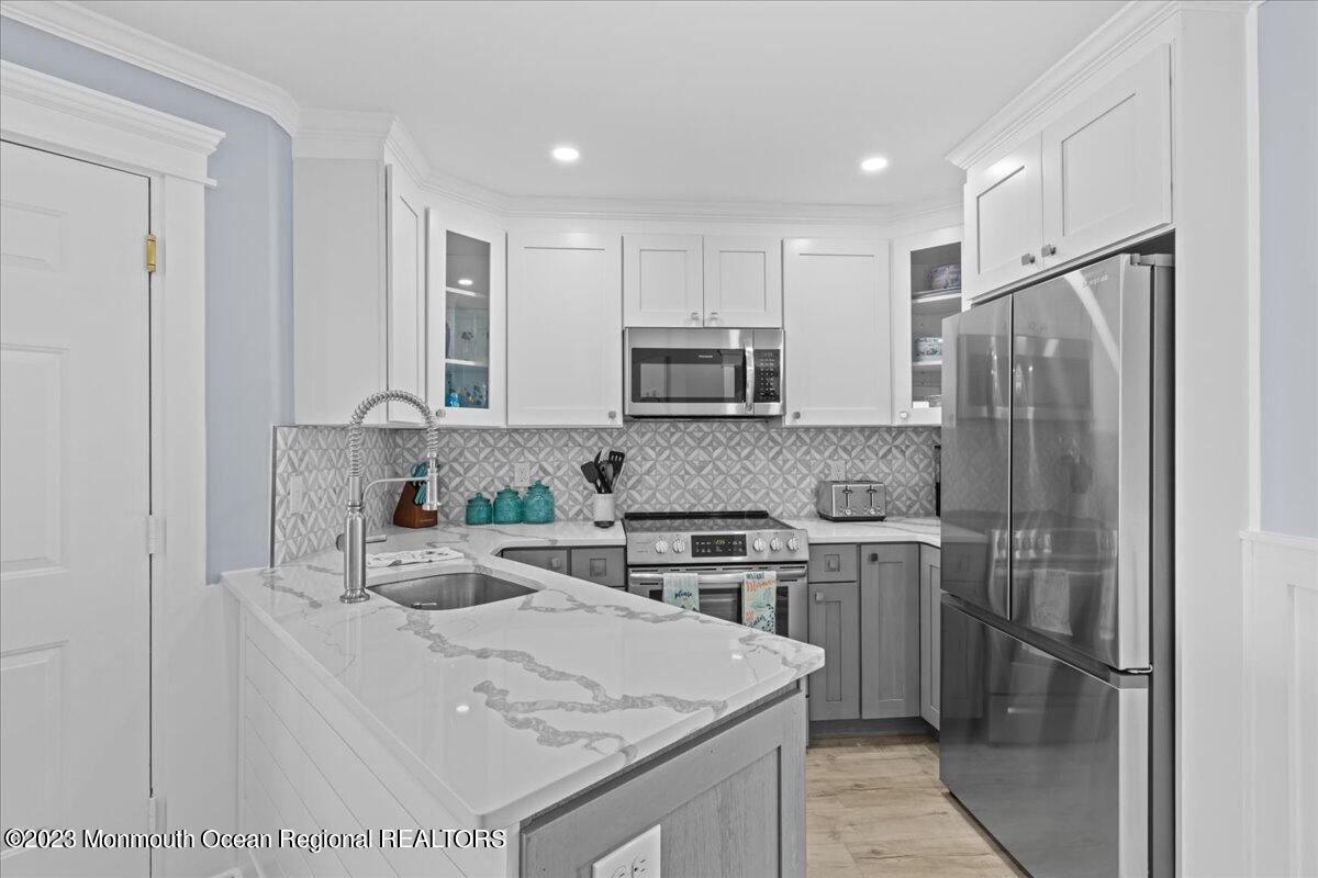 15 Dune Terrace, Unit 15B Seaside Heights, NJ 08751 - Photo 9 of 22 a kitchen with stainless steel appliances granite countertop a sink stove and refrigerator