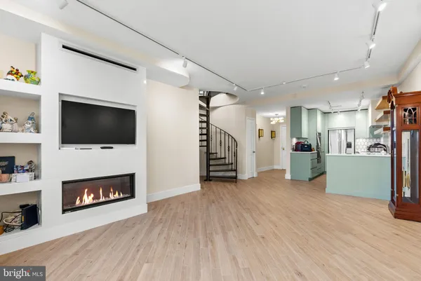 a view of an empty room with wooden floor a fireplace