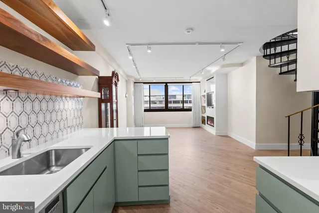 a kitchen with a sink cabinets and wooden floor