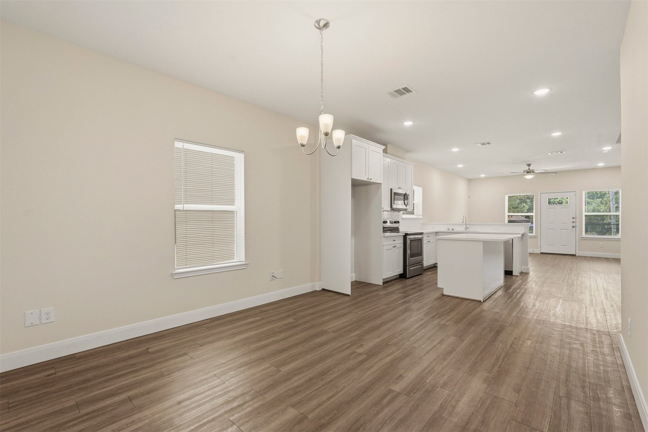 2218 Bringhurst Street, Unit B Houston, TX 77026 - Photo 13 of 25 a view of a kitchen with a kitchen island wooden floor appliances and a window