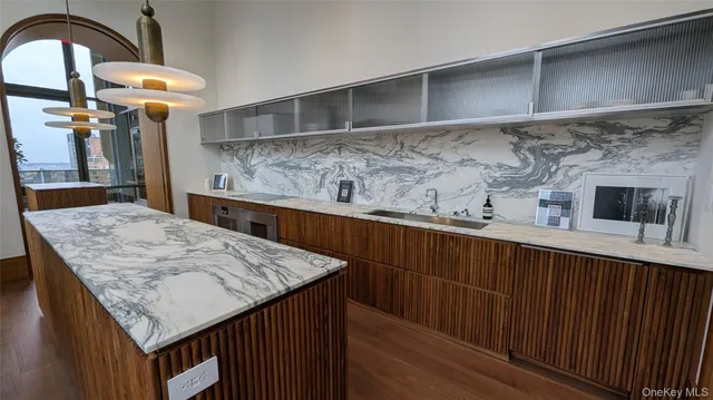 a kitchen with a sink a counter space and wooden floor