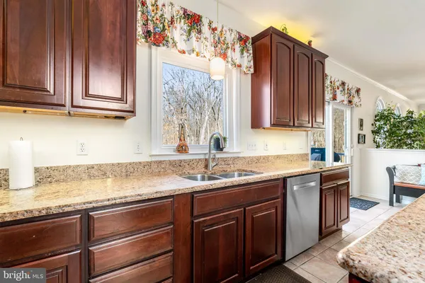 a kitchen with stainless steel appliances granite countertop wooden cabinets a sink and dishwasher