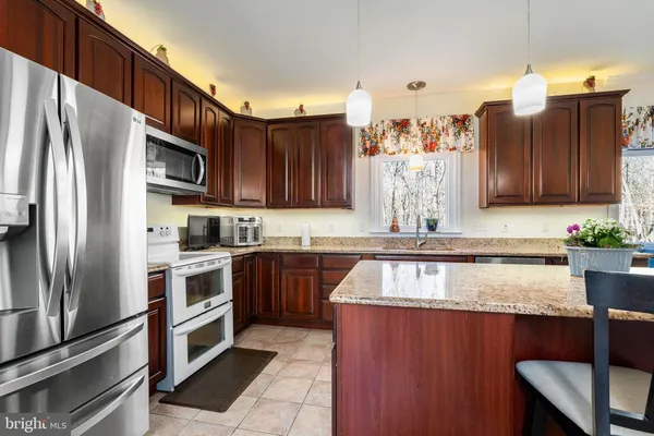 a kitchen with granite countertop stainless steel appliances and wooden cabinets