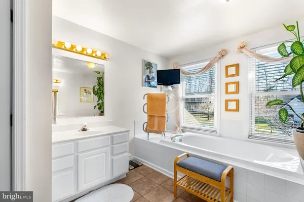 a spacious bathroom with a window double vanity sink and a bathtub