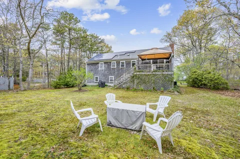 a view of a house with backyard and sitting area