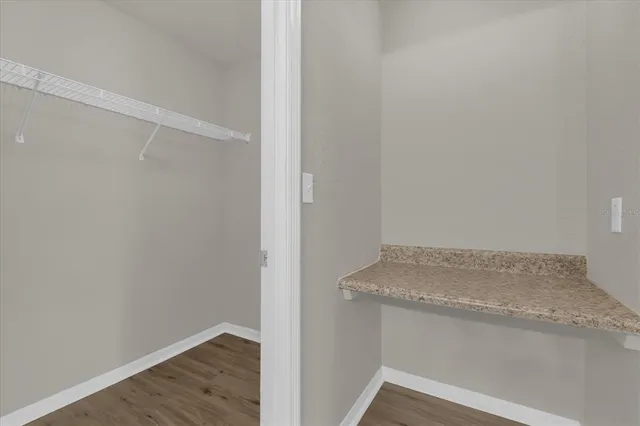 a view of storage and utility room with wooden floor