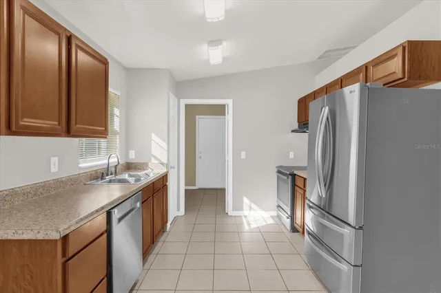 a kitchen with stainless steel appliances granite countertop a refrigerator and a sink