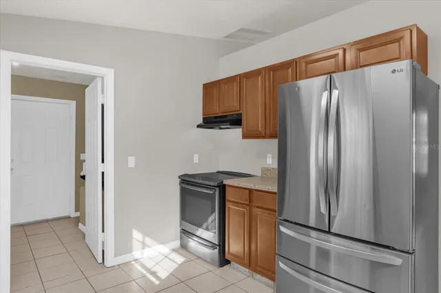 a kitchen with stainless steel appliances granite countertop a refrigerator and a sink