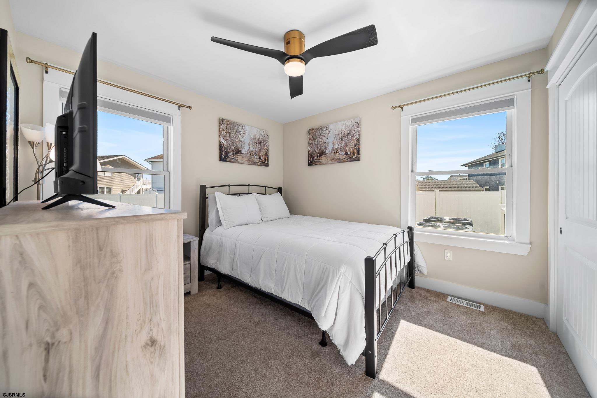 7 A Lighthouse Cove, Unit A Brigantine, NJ 08203 - Photo 19 of 31 a bedroom with a large bed a flat tv screen and a dresser