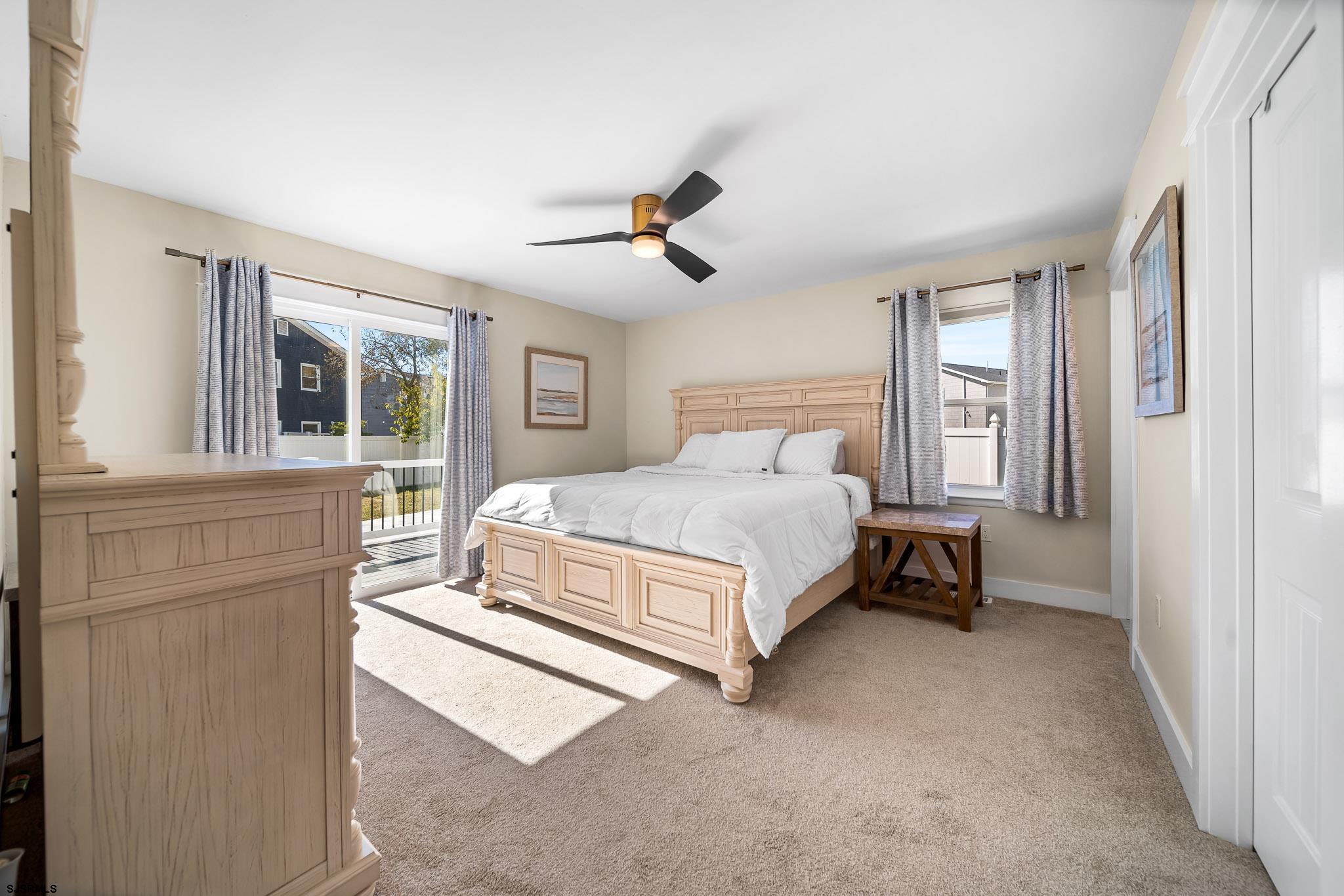 7 A Lighthouse Cove, Unit A Brigantine, NJ 08203 - Photo 20 of 31 a bedroom with a bed next to a window and a chandelier