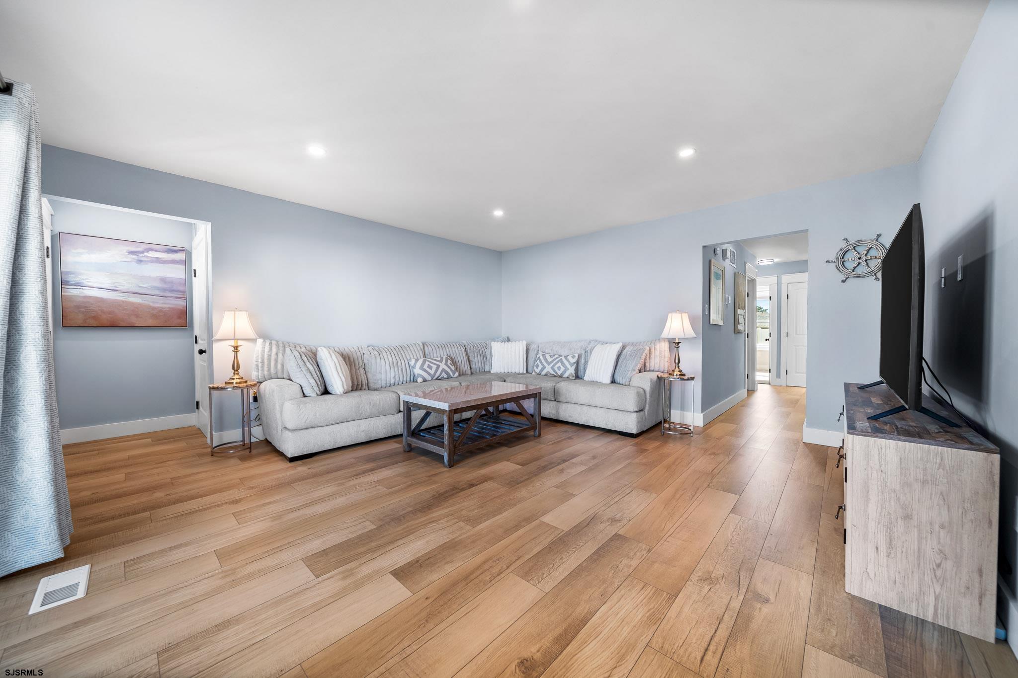 7 A Lighthouse Cove, Unit A Brigantine, NJ 08203 - Photo 8 of 31 a living room with furniture and a flat screen tv
