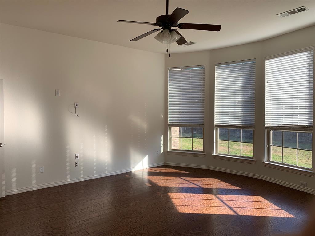 1017 Somerset Circle Forney, TX 75126 - Photo 13 of 21 a view of an empty room with a window and wooden floor