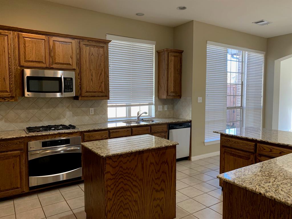 1017 Somerset Circle Forney, TX 75126 - Photo 4 of 21 a kitchen with granite countertop a stove sink and microwave