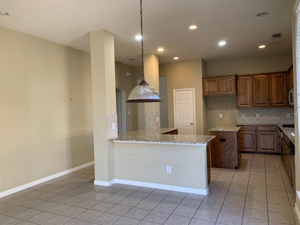 1017 Somerset Circle Forney, TX 75126 - Photo 6 of 21 a kitchen with stainless steel appliances granite countertop a sink and a stove