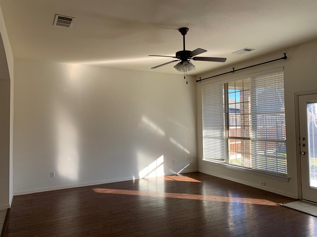 1017 Somerset Circle Forney, TX 75126 - Photo 8 of 21 a view of an empty room with wooden floor and a window